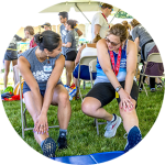 Male athlete holding form in a basketball game wearing a grey jersey with green stars and a Patriots mask on his face.