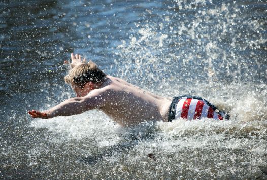 Athlete wearing an American Flag bathing suit diving into the water.