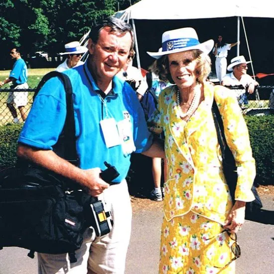 Eunice Kennedy Shrive wearing a yellow skirt and top standing outside with a man wearing a blue shirt.