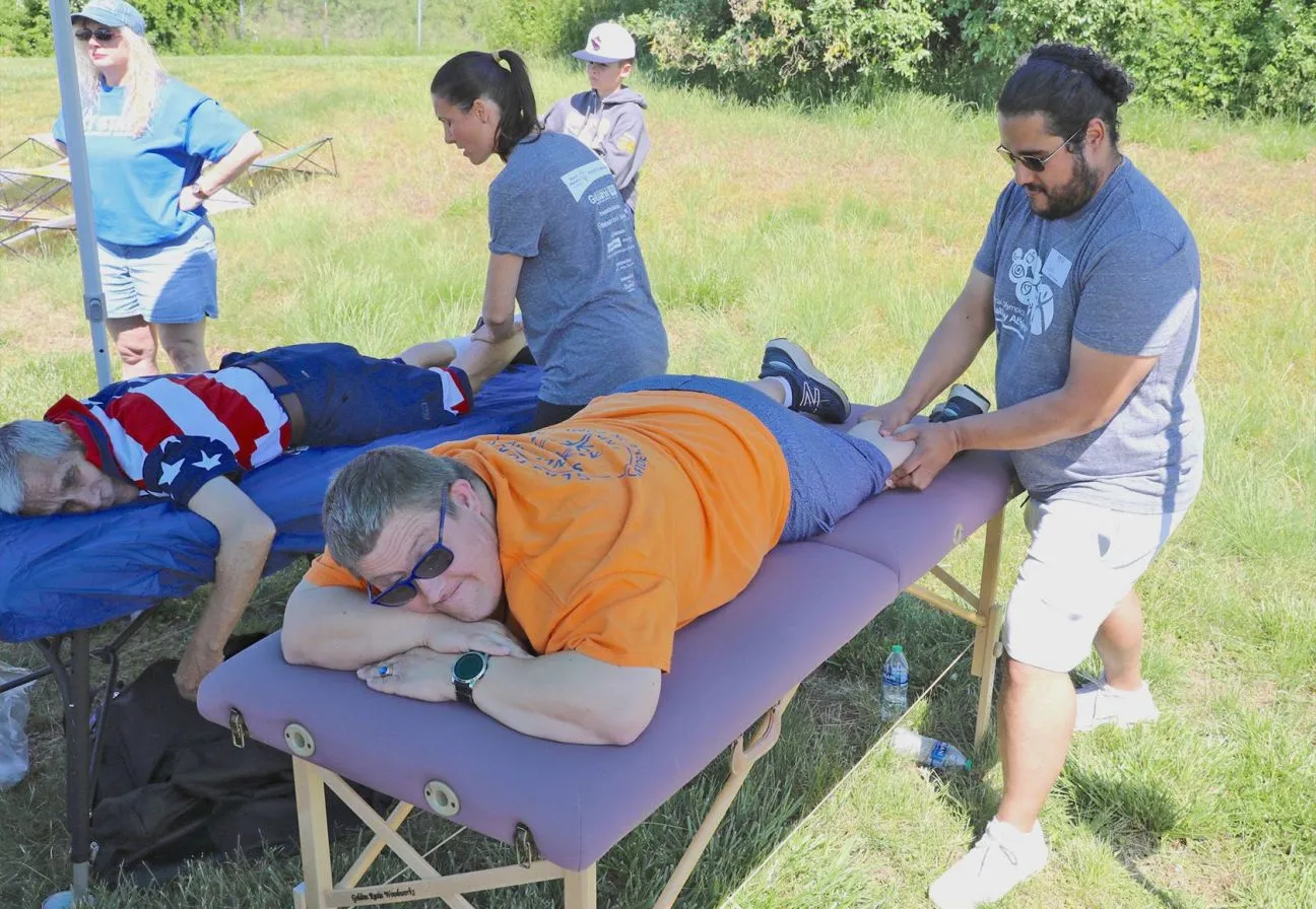 Men and women standing and sitting outside listening to a women present a pie chart.