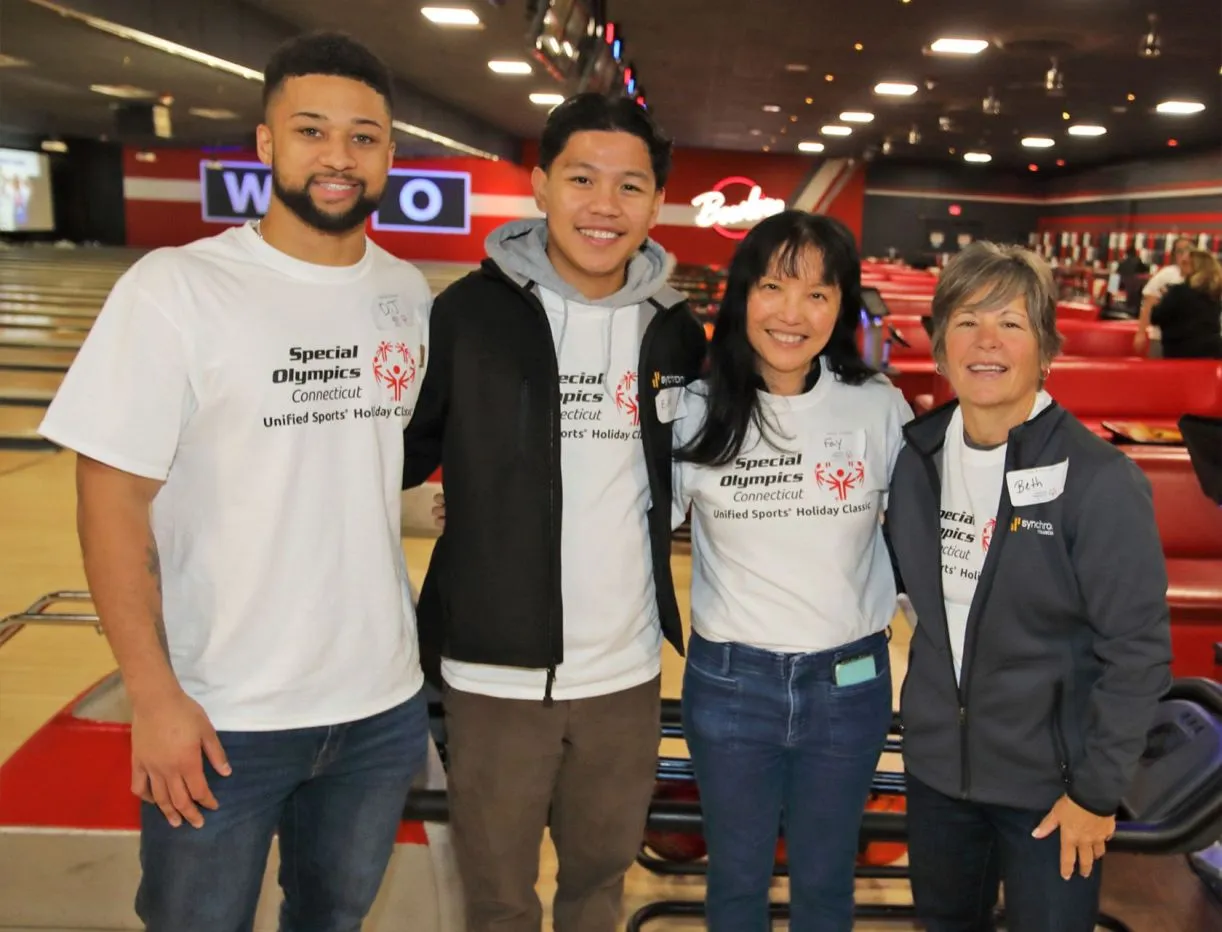 Volunteers standing next to each other wearing grey and navy blue 
