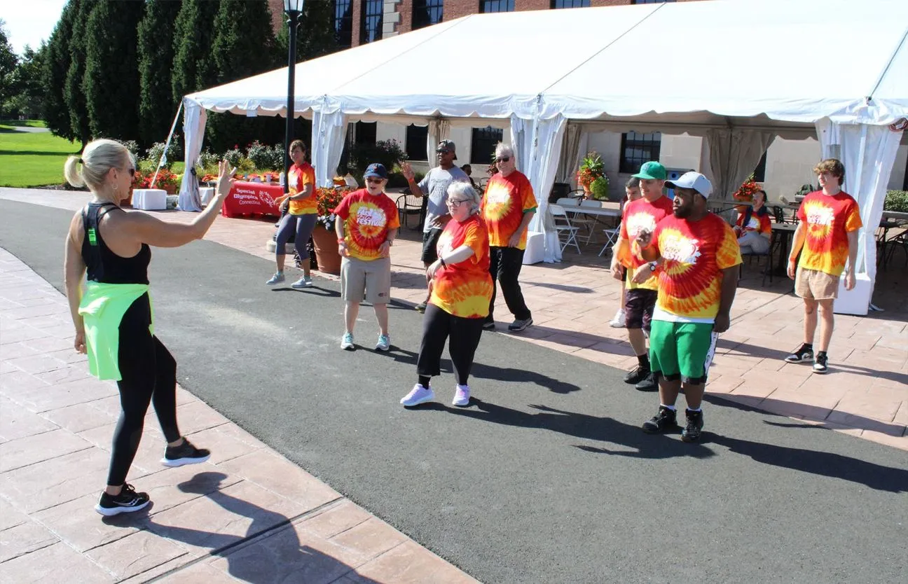 Athletes working with trainer in a fitness class outside.