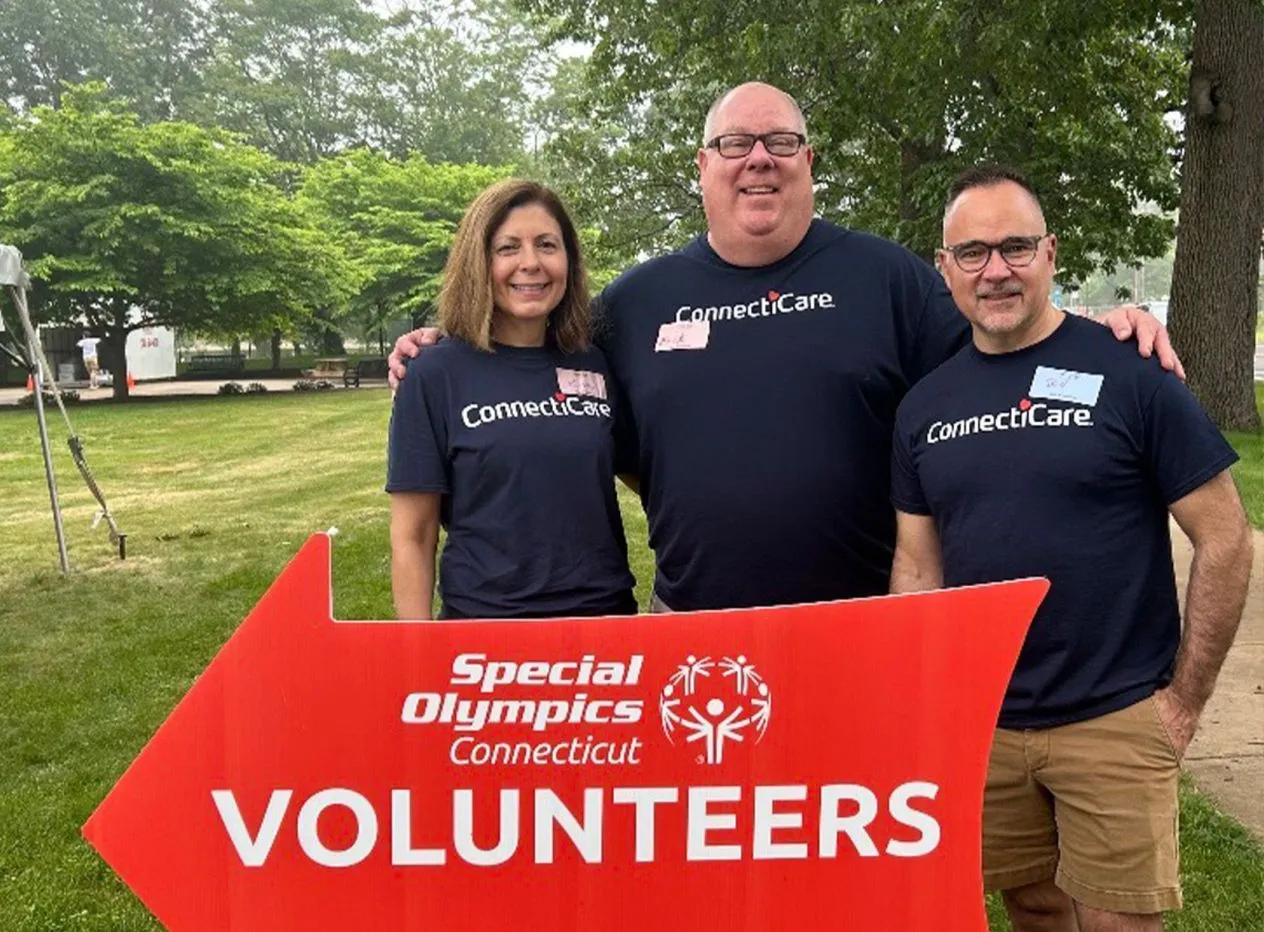 Young volunteer presenting an athlete with a medal by placing it over his head.
